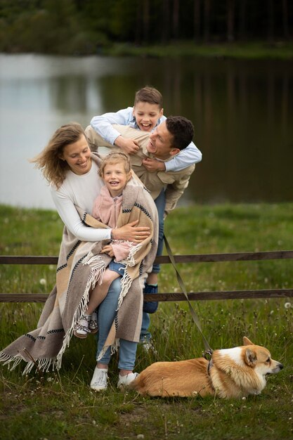 Tiro completo familia feliz y perro al aire libre