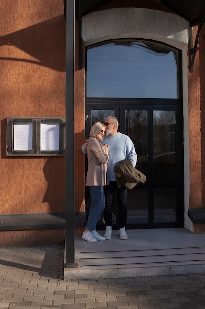 Foto gratuita tiro completo feliz pareja senior al aire libre