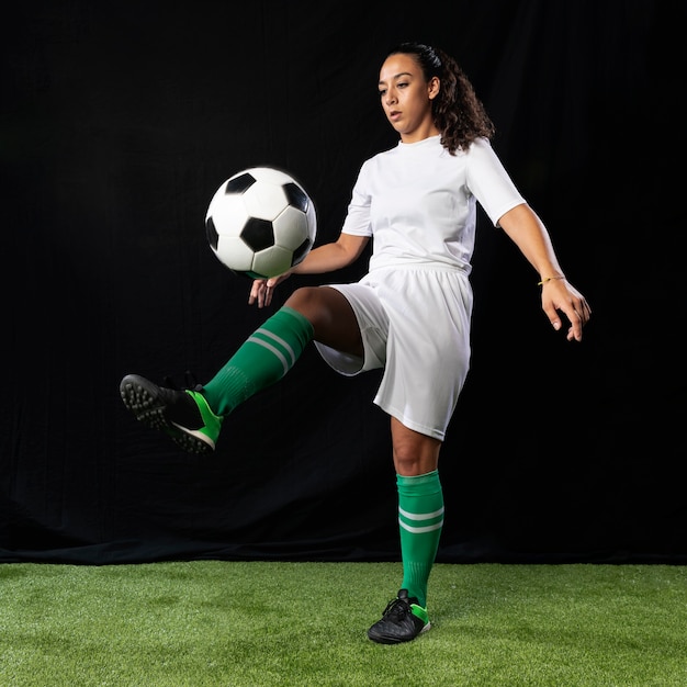 Tiro completo femenino jugando al fútbol