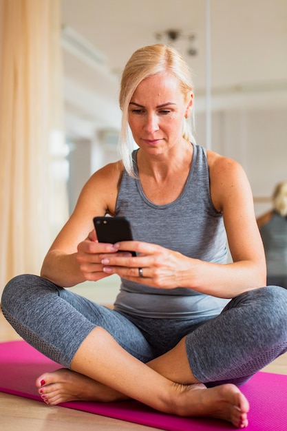 Foto gratuita tiro completo fit mujer revisando su teléfono