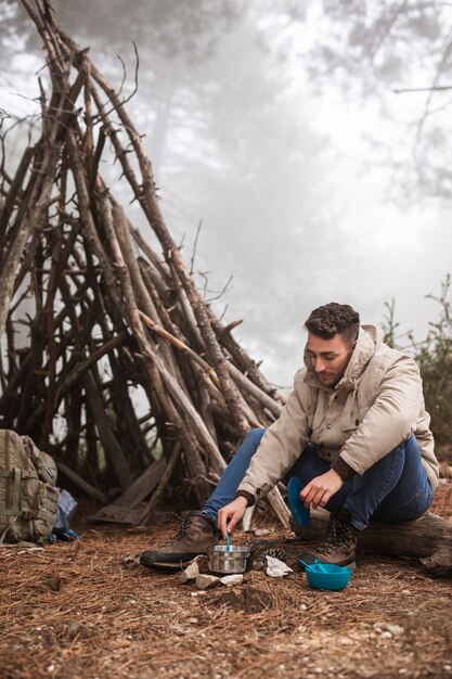 Tiro completo hombre cocinando en la naturaleza