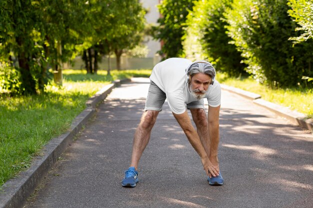 Tiro completo hombre estirando al aire libre