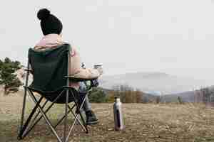 Foto gratuita tiro completo hombre sentado en una silla al aire libre