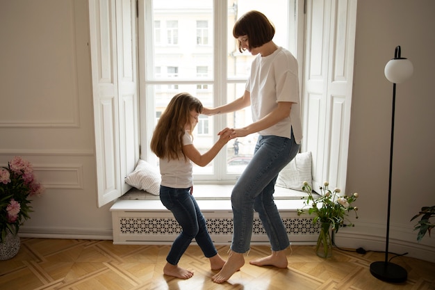 Tiro completo madre y niña bailando dentro