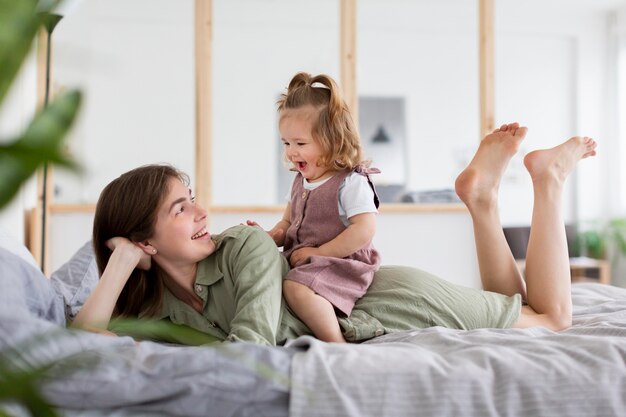 Tiro completo madre y niña en la cama