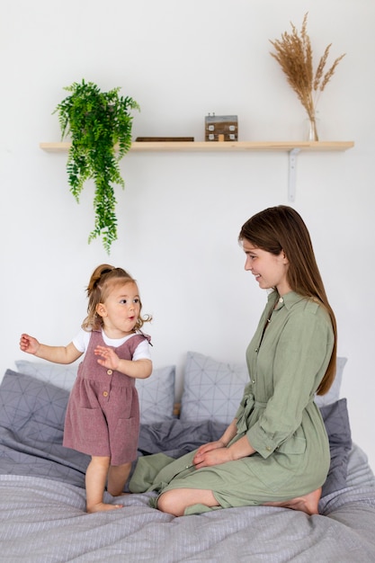 Tiro completo madre y niña en la cama