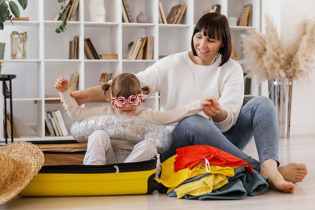 Foto gratuita tiro completo madre y niña con equipaje