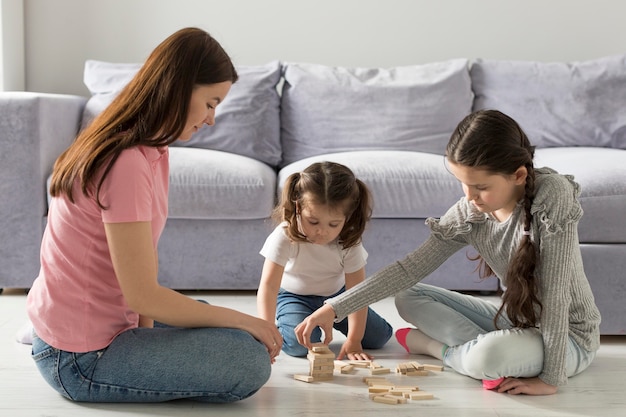 Tiro completo madre y niñas en el piso