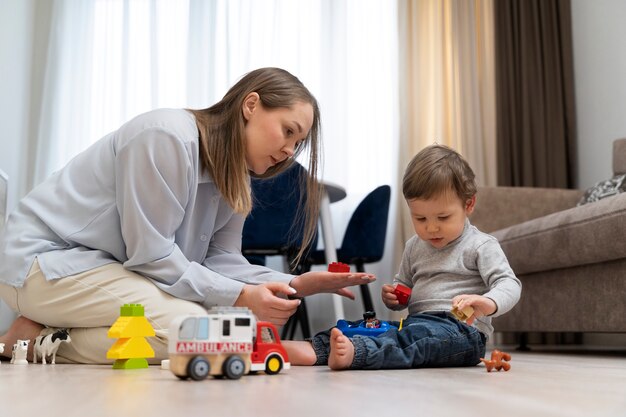 Tiro completo madre y niño jugando con juguetes