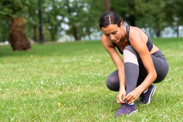 Tiro completo mujer atando sus cordones