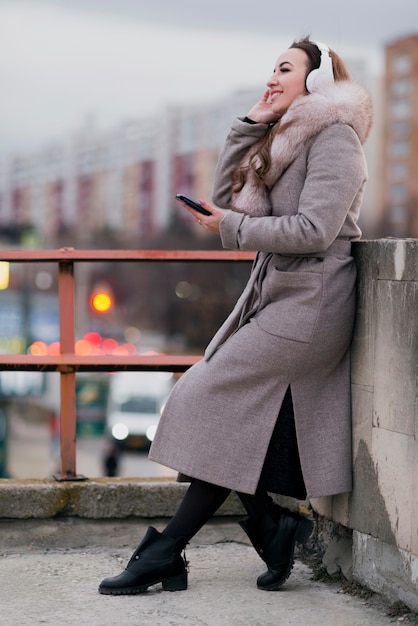 Foto gratuita tiro completo mujer con auriculares en techo