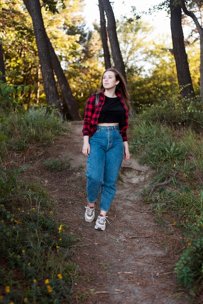 Tiro completo mujer de cabello castaño en el bosque