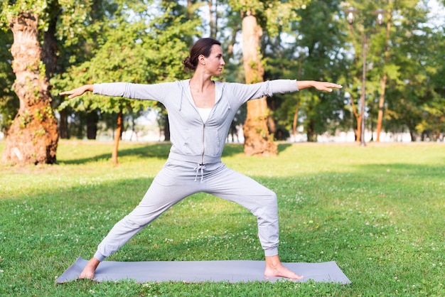 Tiro completo mujer entrenamiento en estera de yoga