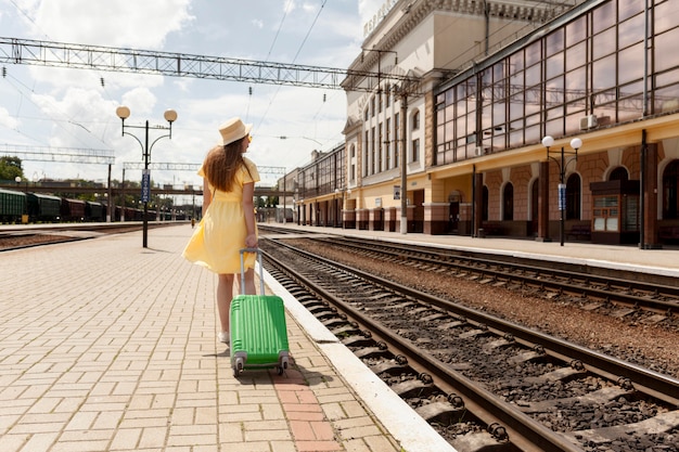 Foto gratuita tiro completo mujer en la estación de tren