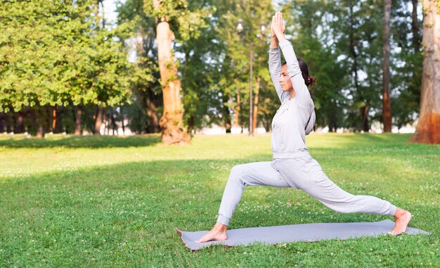 Tiro completo mujer estirando sobre estera de yoga