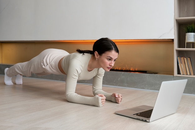 Tiro completo mujer haciendo ejercicio en interiores