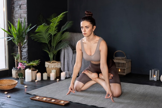 Tiro completo mujer haciendo yoga en el interior