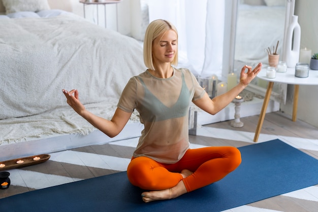 Tiro completo mujer haciendo yoga en mat