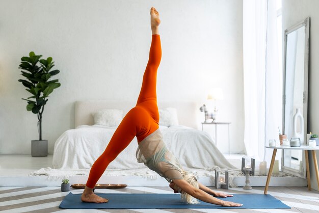 Tiro completo mujer haciendo yoga en mat