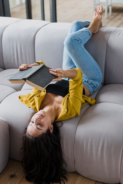 Tiro completo mujer leyendo en el sofá