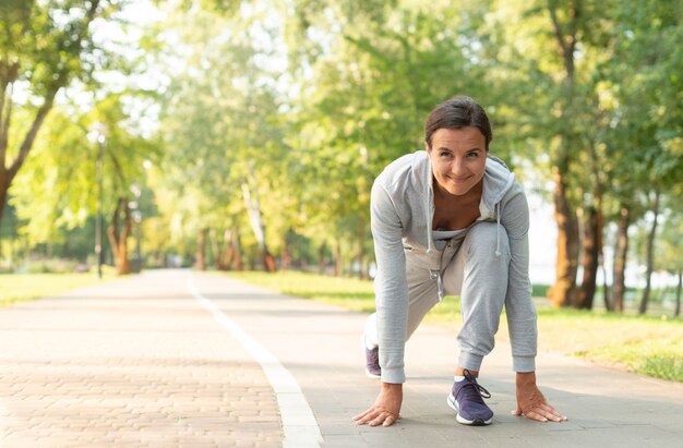 Tiro completo mujer lista para correr en la naturaleza