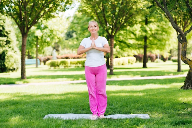 Tiro completo mujer meditando posición al aire libre