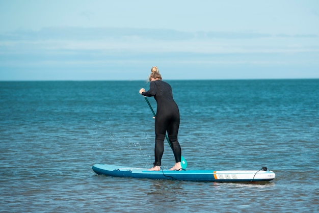 Tiro completo de mujer paddleboarding