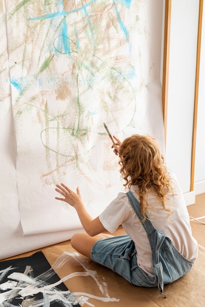 Foto gratuita tiro completo mujer pintando en la pared