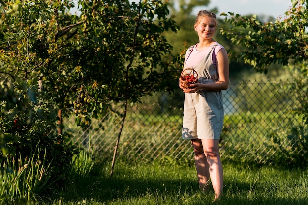 Foto gratuita tiro completo mujer posando con cesta de frutas