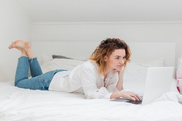 Tiro completo mujer que trabaja en la cama