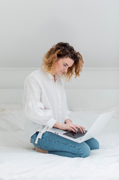 Tiro completo mujer que trabaja en la computadora portátil