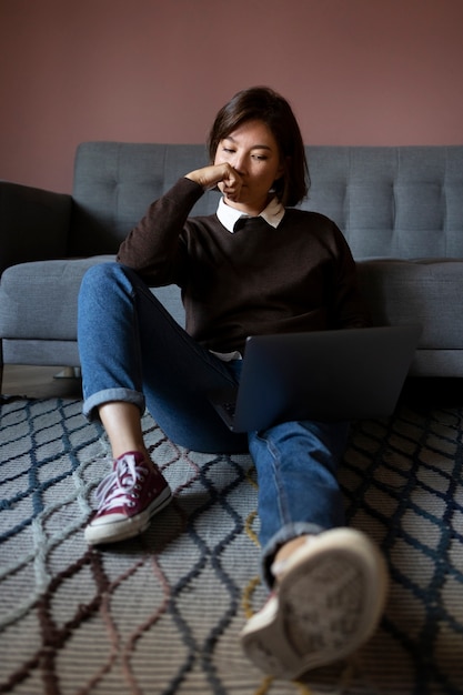 Tiro completo mujer que trabaja en la computadora portátil