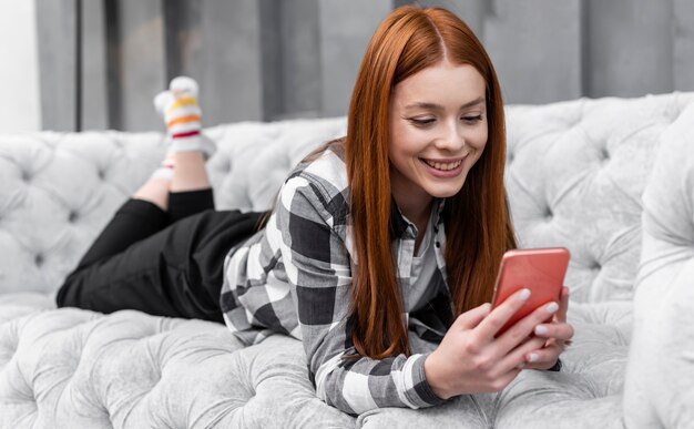 Tiro completo mujer relajante con Smartphone