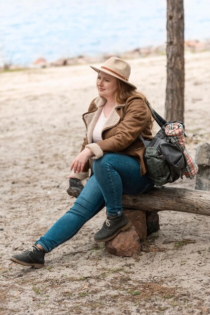 Tiro completo mujer sentada al aire libre