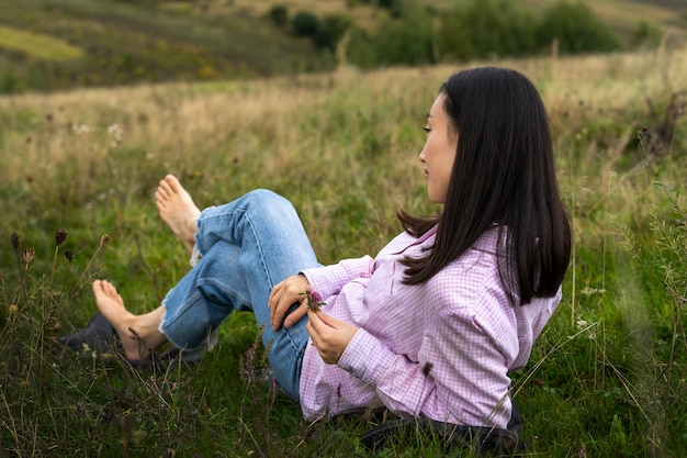 Foto gratuita tiro completo mujer sentada al aire libre