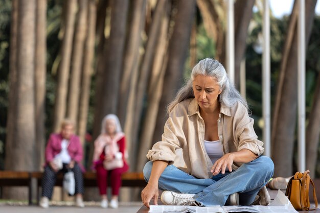 Tiro completo mujer sentada al aire libre