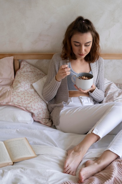 Foto gratuita tiro completo mujer sentada en la cama