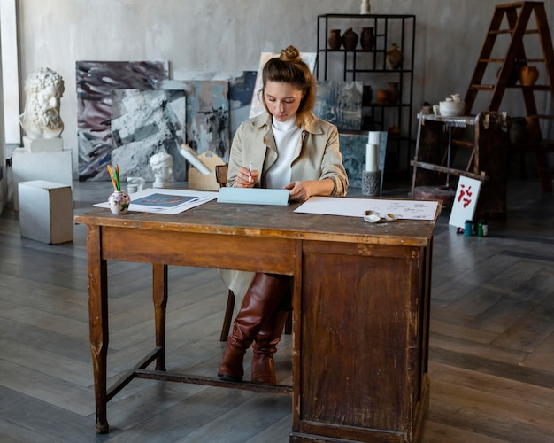 Tiro completo mujer sentada en el escritorio