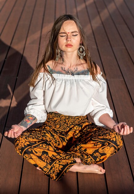 Tiro completo mujer sentada y meditando