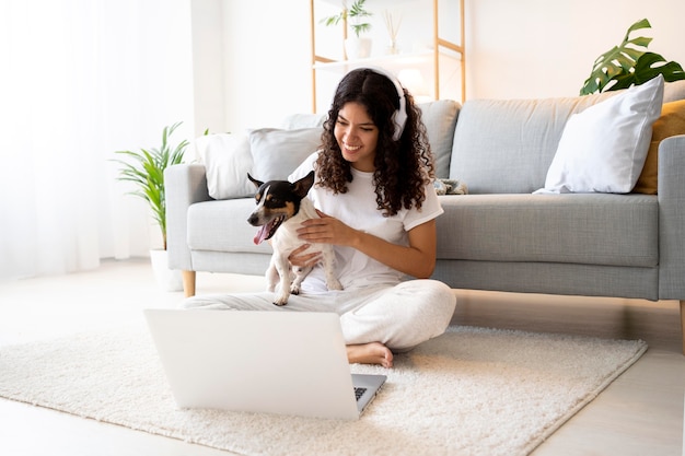 Tiro completo mujer sentada en el piso con mascota