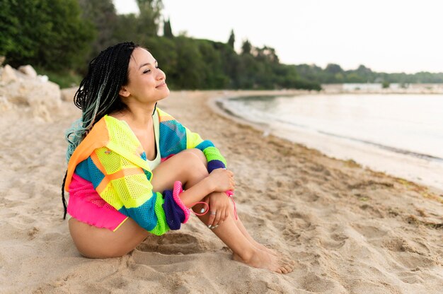 Tiro completo mujer sentada en la playa