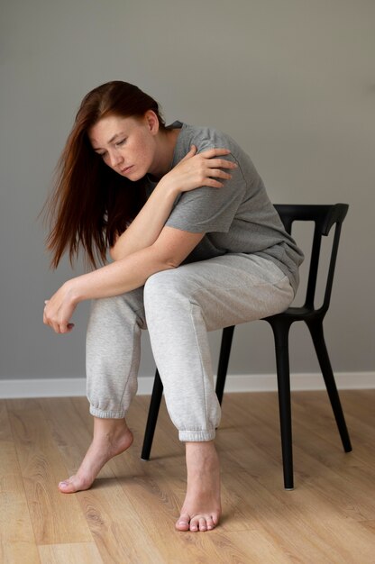 Tiro completo mujer sentada en una silla