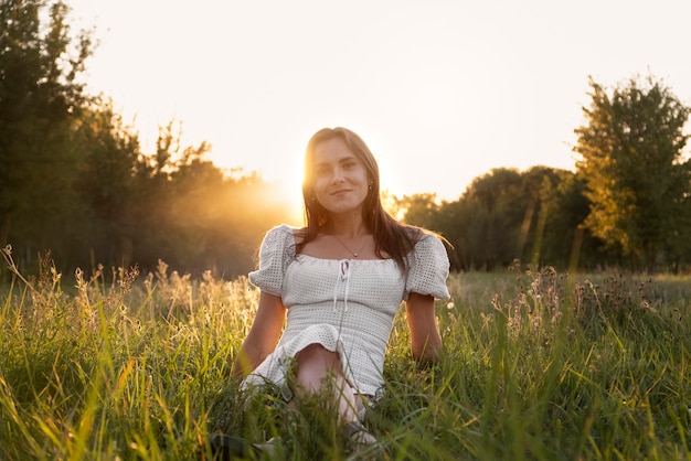 Foto gratuita tiro completo mujer sentada sobre el césped