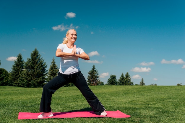 Foto gratuita tiro completo mujer sonriente haciendo ejercicio al aire libre