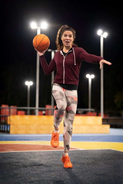 Tiro completo mujer sosteniendo baloncesto