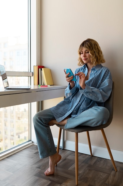 Tiro completo mujer sosteniendo smartphone