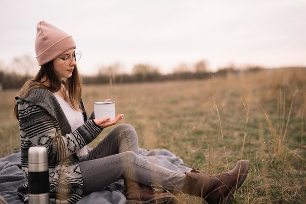 Tiro completo mujer sosteniendo la taza de café