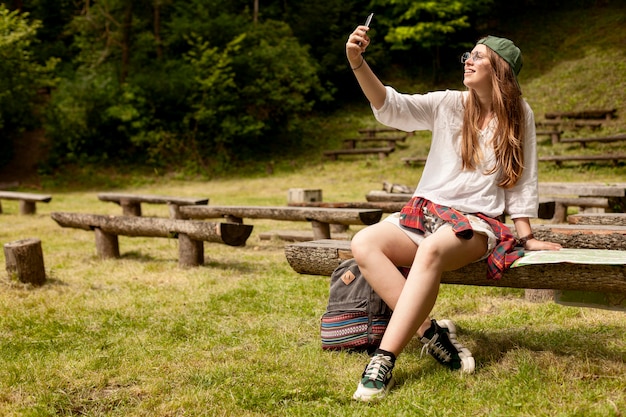 Foto gratuita tiro completo mujer tomando selfie