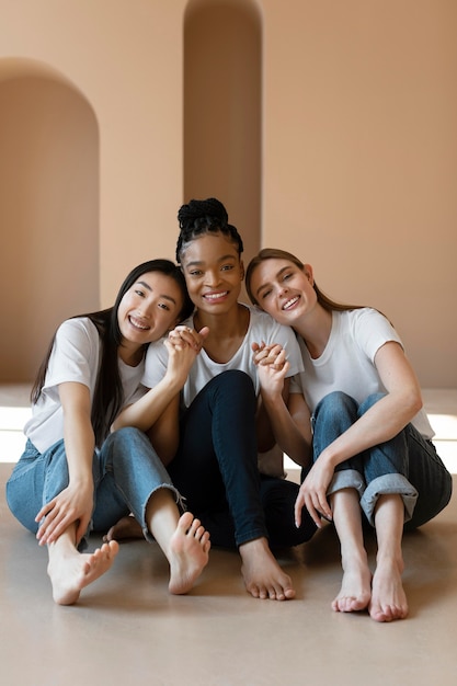 Foto gratuita tiro completo mujeres felices sentadas en el piso