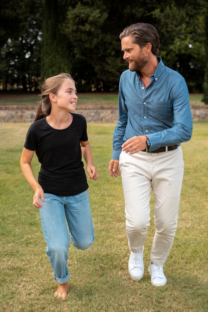 Tiro completo niña y hombre corriendo juntos